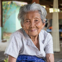 Old_woman_of_Don_Puay_white_shirt_grey_hair_wrinkled_skin